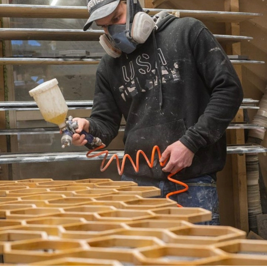 person spray painting toilet paper holder