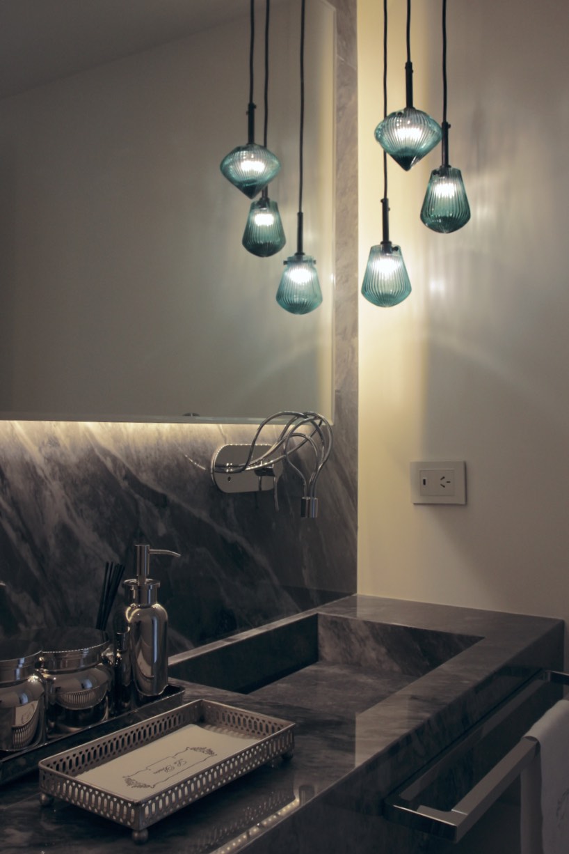 Bathroom design with a pop of green color and a current light fixture designed by Tom Dixon in contrast with the honed grey marble. Restoration Hardware accessories.