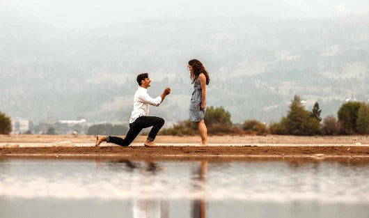 couple getting engaged next to a lake