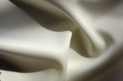 A closeup shot of an off-white polyester fabric.