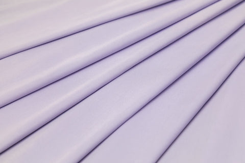 A closeup shot of a lilac coloured sateen cotton fabric.