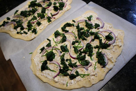 two german pizza with cream fraiche, spinach and salmon