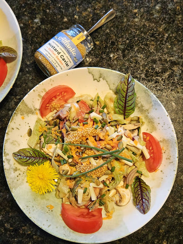 A plate with a salad and a jar of wholes seed mustard called Sicilian Garden