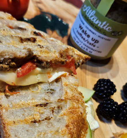 A grilled sandwich with a bottle of coffee mustard