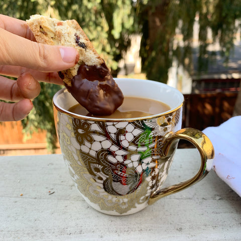 intricate tea cup with milky tea dipped gluten free biscotti