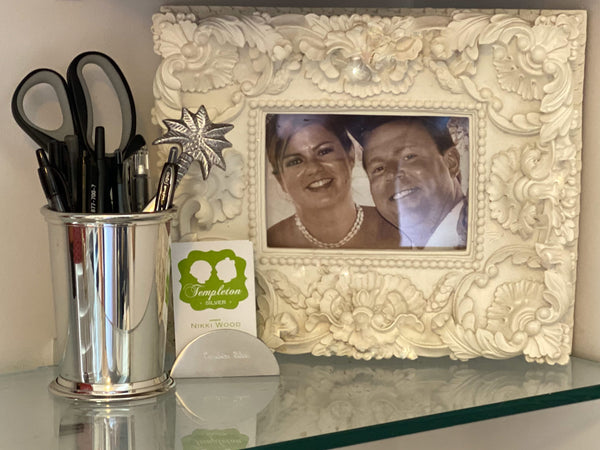 framed image of a wedding couple, business cards and mint julep cup as a pen holder