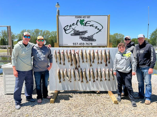 people standing next to caught fish