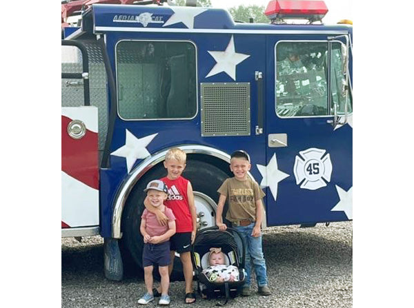 kids standing in front of fire truck