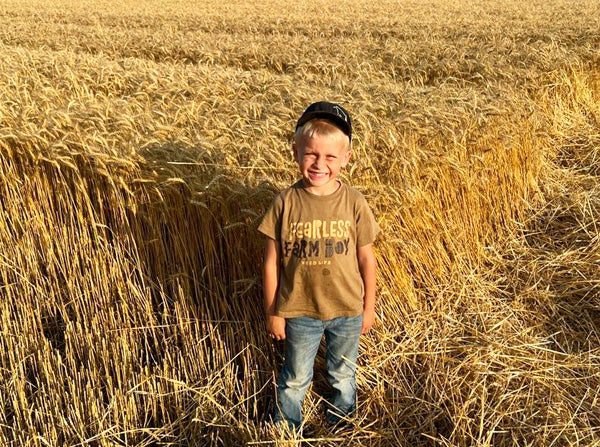 boy standing in wheat field