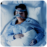 Woman sleeping with a device to assist with sleep apnea