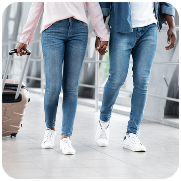 Man and woman holding hands as they walk through airport terminal