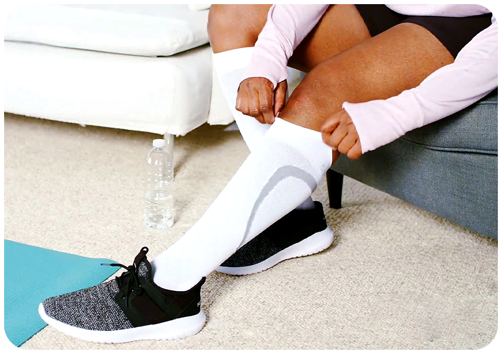 woman pulling on a pair of white athletic compression socks