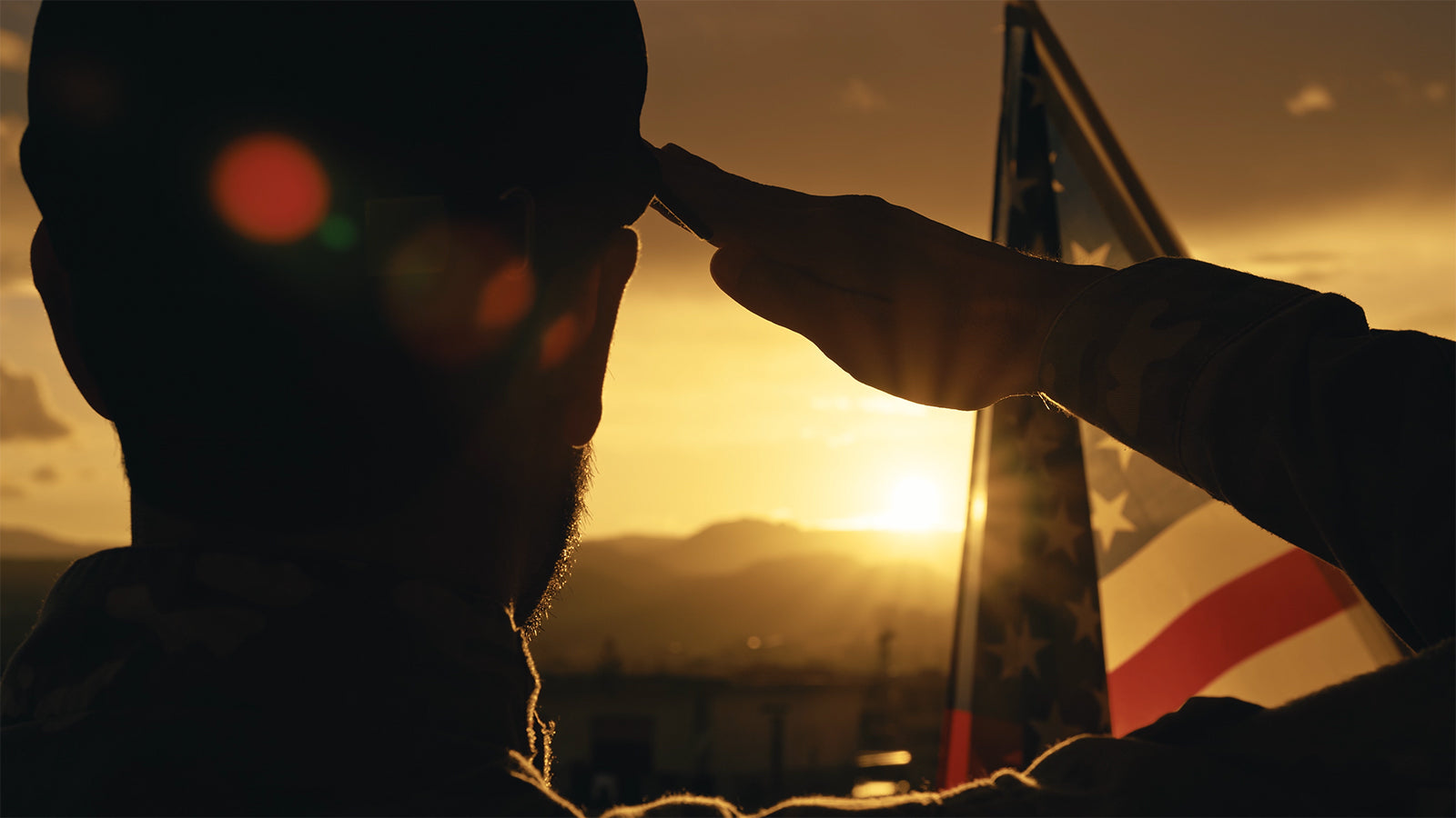 Sunset Salute American soldier saluting flag as sun sets behind it