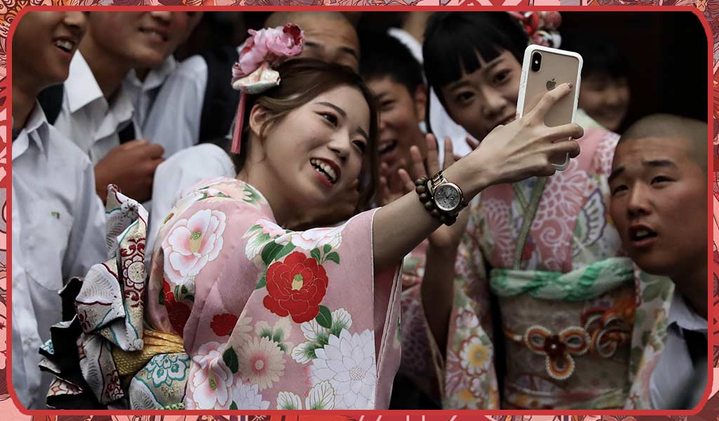 a woman celebrating the adult day Seiji No hi by taking a picture with a new day kimono and its friends