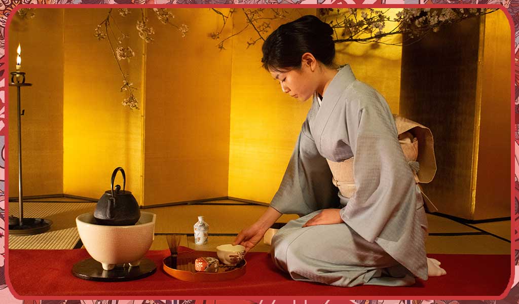 Woman wearing a Japanese ceremonial kimono while preparing the tea ceremony