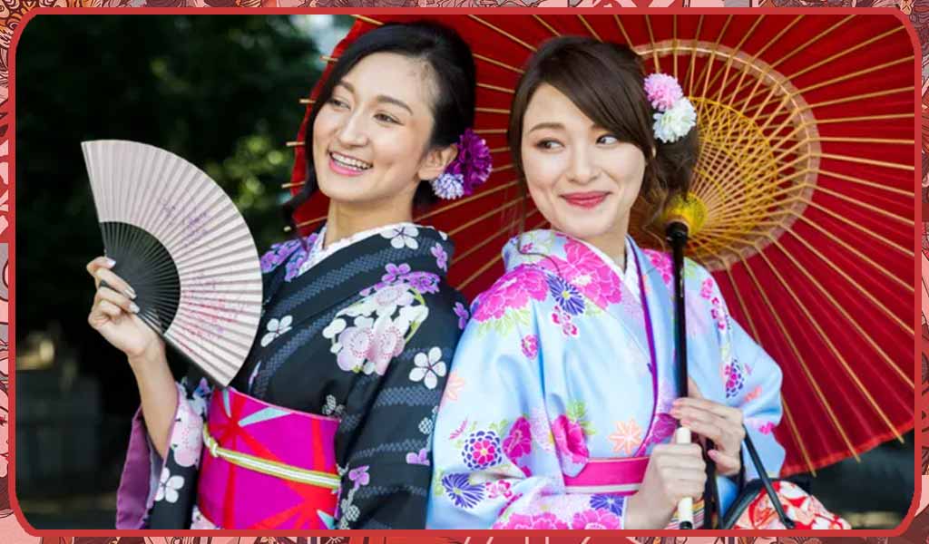 Two women are wearing an awase kimono and a hitoe kimono. They carry a folding fan and a Japanese parasol.