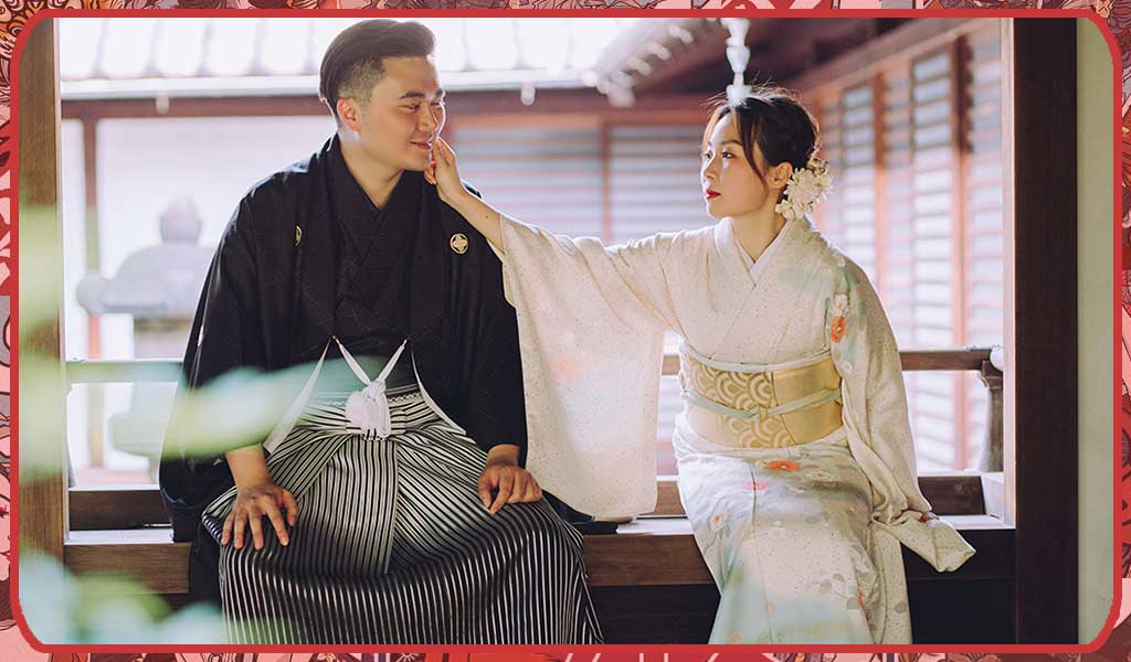 A man and a woman wearing a black and white Japanese kimono with an obi belt