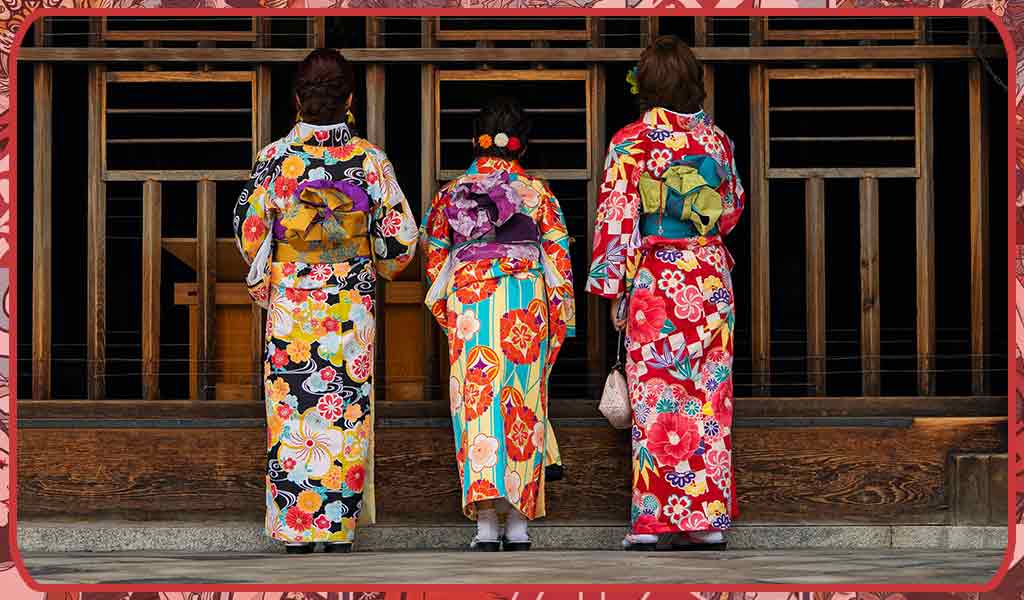 three women in kimono robes are praying in a shinto temple