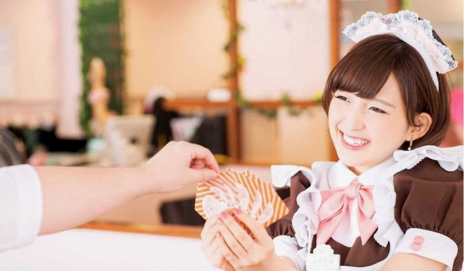 Japanese Maid dressed as a maid playing cards with a customer