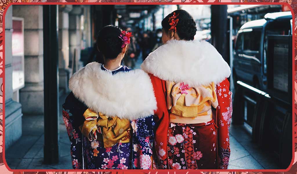 Two Japanese girls wearing a women's winter kimono, an obi belt and a Kanzashi hair comb