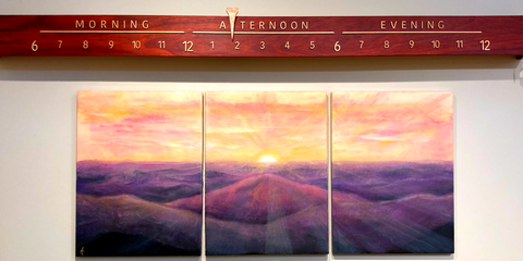 Large clock above paintings of the Blue Ridge Mountains.