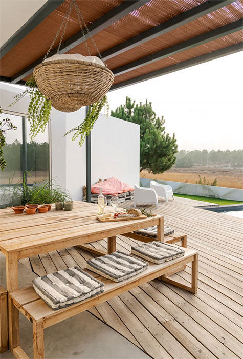Photo of wooden deck with outdoor table and seating area.