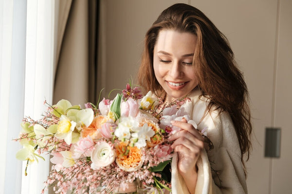 Mujer Sonriendo con ramo de rosas al interior de su casa