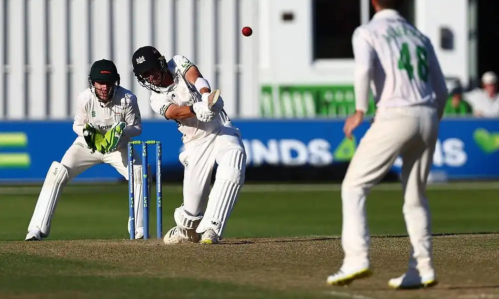 A game of county cricket championship, a player hits the ball