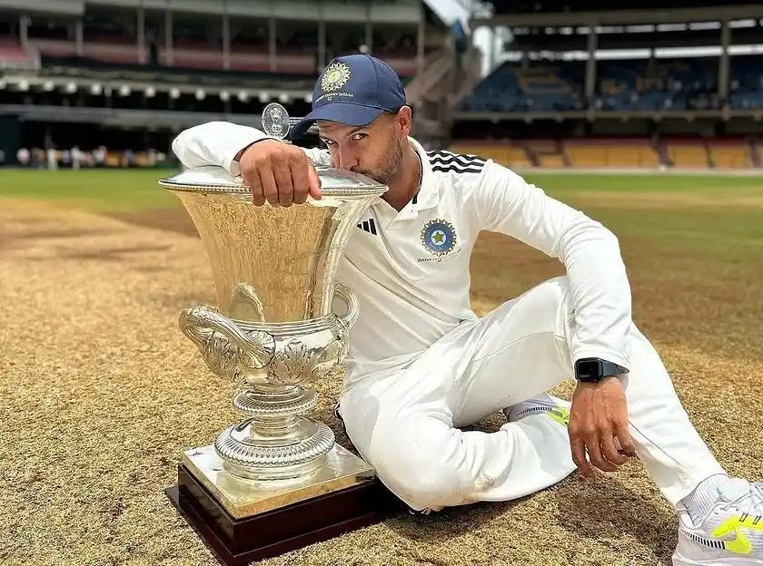 Mayank Agarwal sitting on the pitch along with the Duleep trophy and kissing it