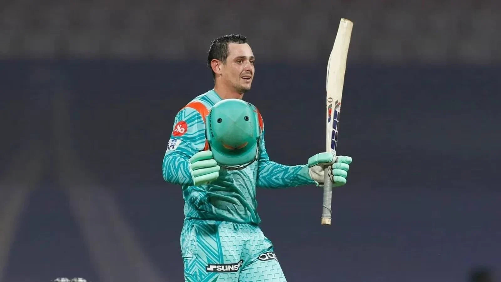 Quinton de Cock raises his bat to celebrate his 100 against KKR while on his way to scoring 140