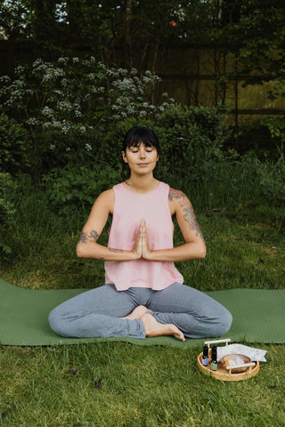 Woman Performing Lotus Yoga Meditation On Grass Outside