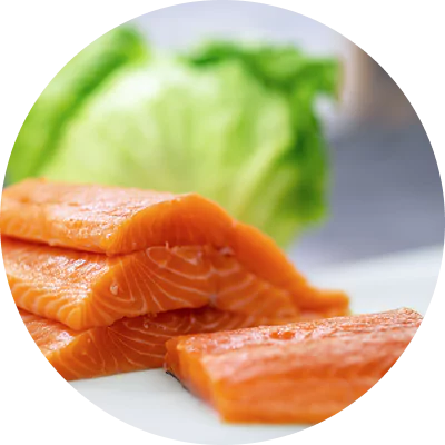 Slices of raw salmon with a backdrop of fresh lettuce.