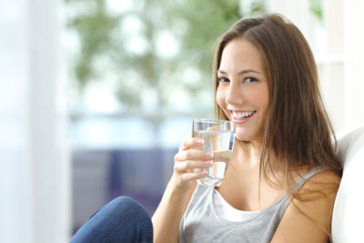 Frau trinkt Wasser und lacht