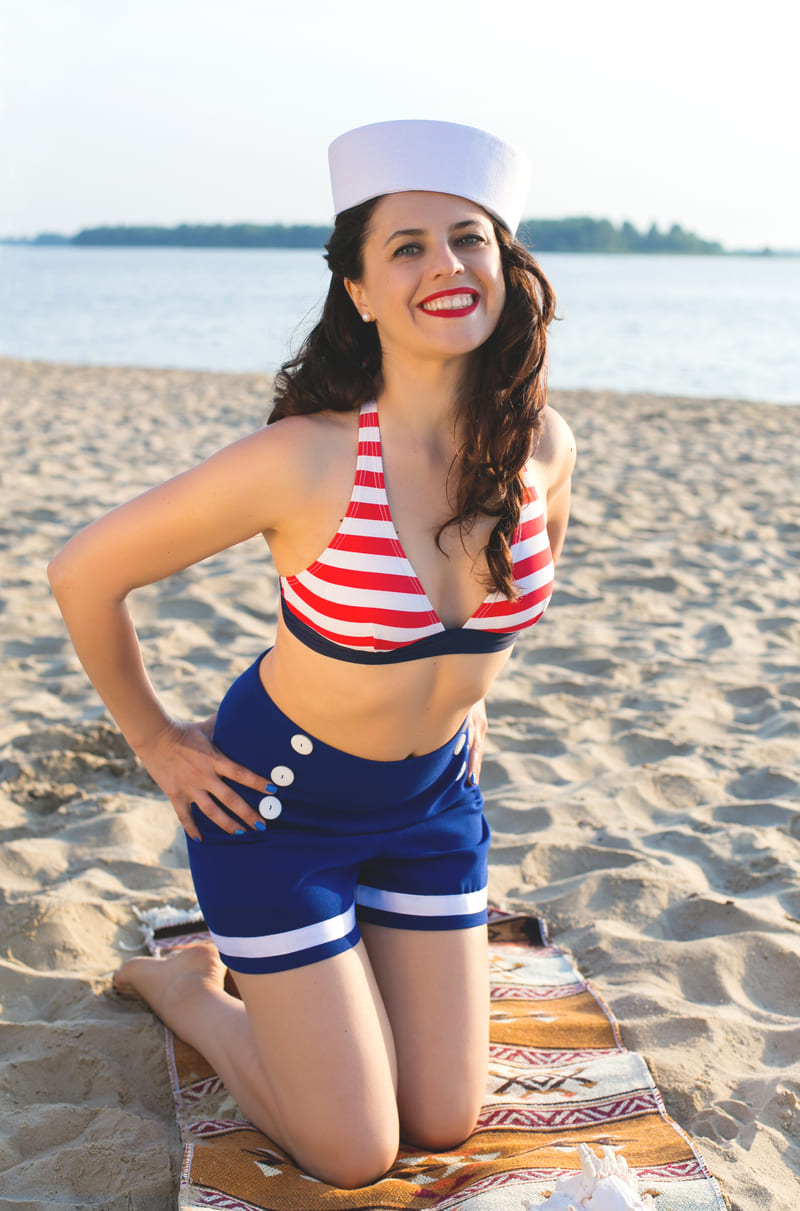 Pin-up joyeuse avec un soutien gorge rayé, sur la plage