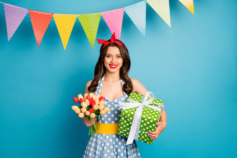 Femme avec fleurs, bandana, cadeau et banderole de fête