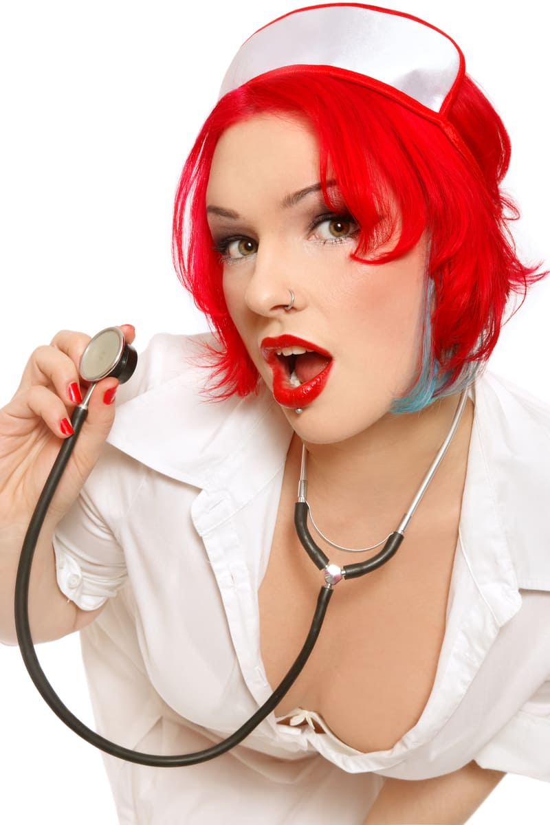 Charmante infirmière rousse avec une blouse blanche et un stéthoscope