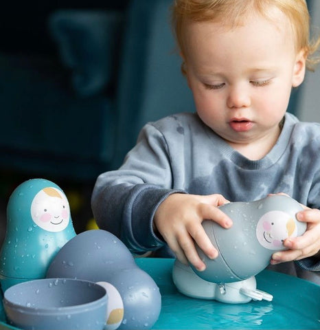 toddler playing with russian dolls nesting babies and water