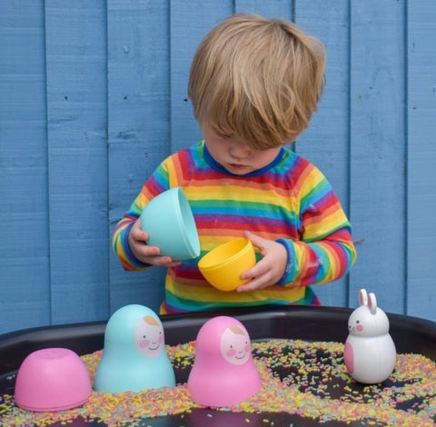 boy playing with rice and nesting babies toddler toy