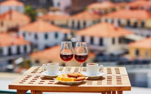 Zwei Gläser Madeira Likörwein auf einem Tisch mit Madeira im Hintergrund