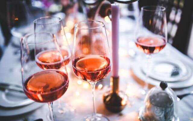 Mehrere Roséwein Gläser auf einem festlich gedeckten Tisch