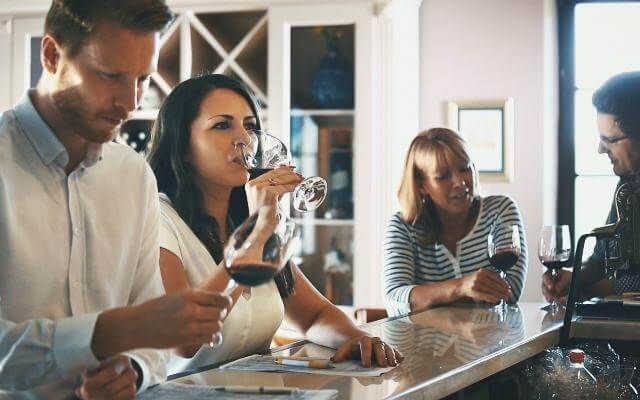 Gruppe von Menschen probiert verschiedene Weine an einer Bar