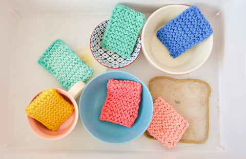 Sink with colorful dishes and Paloma Danger Forever Sponges in pastel colors