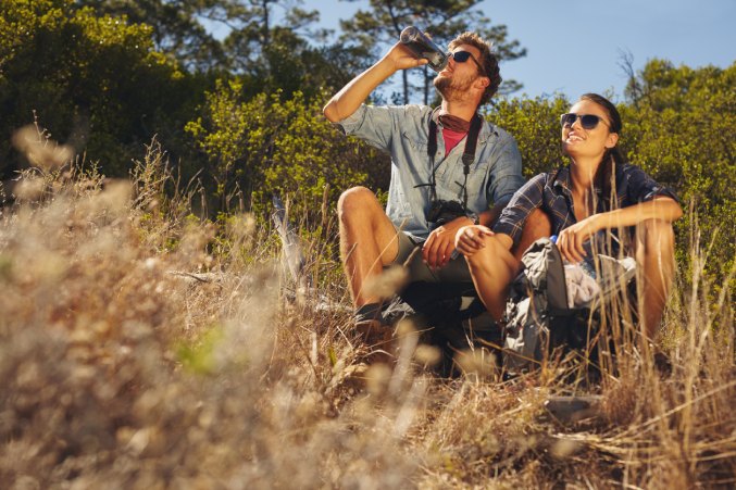 Hikers drinking from water bottle on a break from their hike