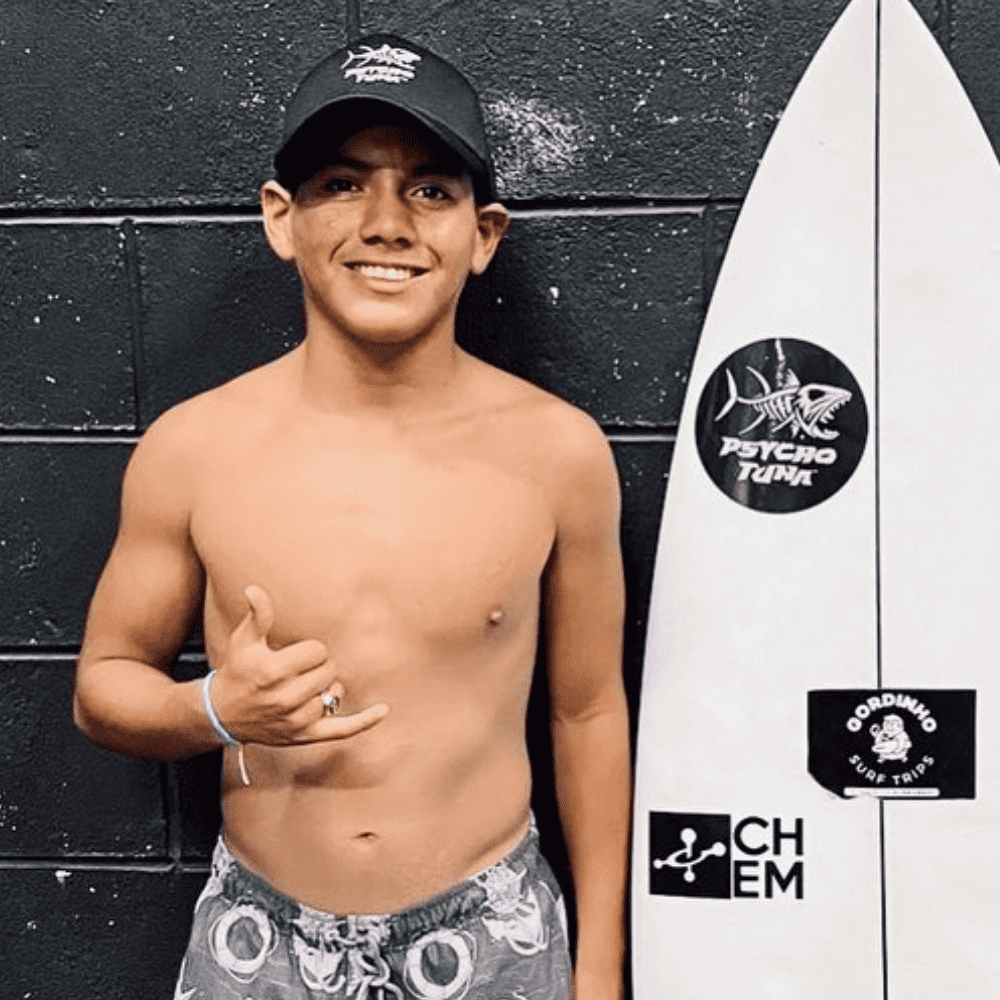 Melvin Ayala headshot with Psycho Tuna surfboard