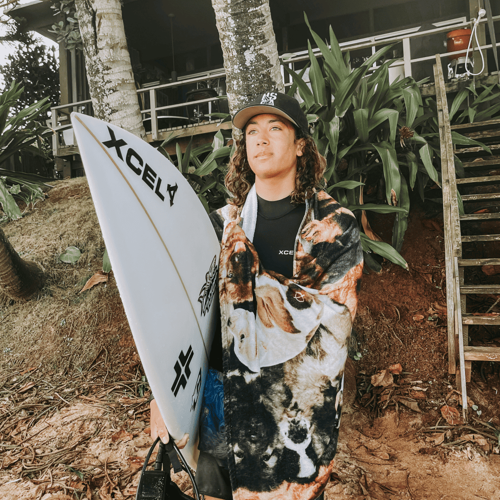 Titus Kaimana Santucci holding a surf board