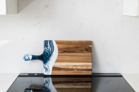 large acacia cheese board in white kitchen with an engraving on it