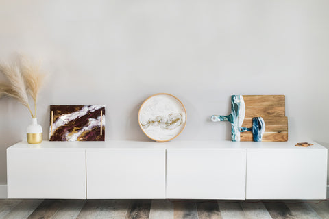 Resin accented Cheese boards leaned up against white walls as decoration