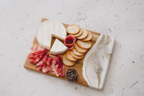 gold quartz style cheese board with brie cheese and salami 