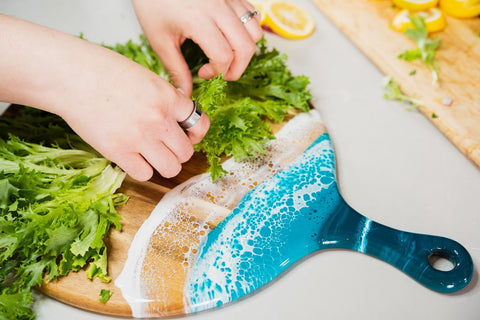 placing lettuce on a resin cheese board