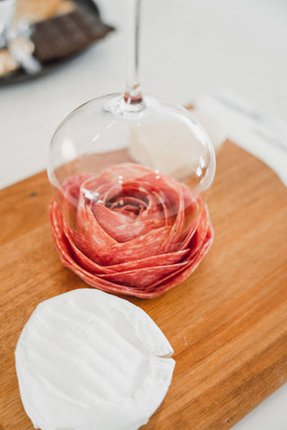 Salami rose made using a wine glass and placed on cheese board
